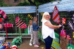 School children and passers-by weave blooming marvellous work of art