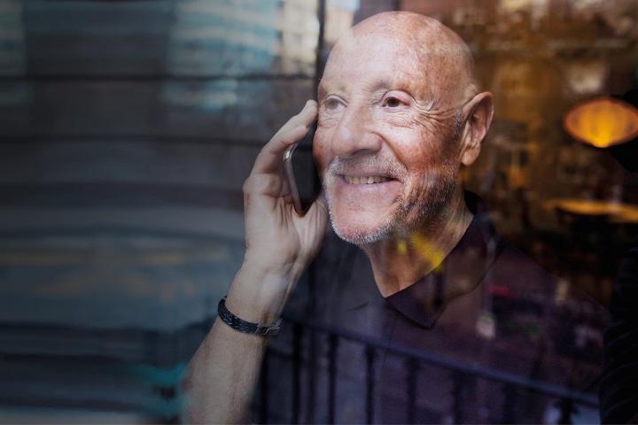 Everyday Hero Elderly man looking through the window talking on phone-1200x1800EXT (2)