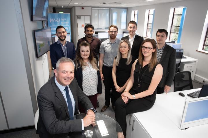 MD John Whelan (front left) with Customer Services Mgr Katie Allen (sitting right) and the My Digital Accounts team in Wilmslow